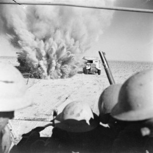 El Alamein: A mine explodes close to a British truck as it carries infantry through enemy minefields and wire to the new front lines.