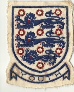 John's England badge bearing the Three Lions.